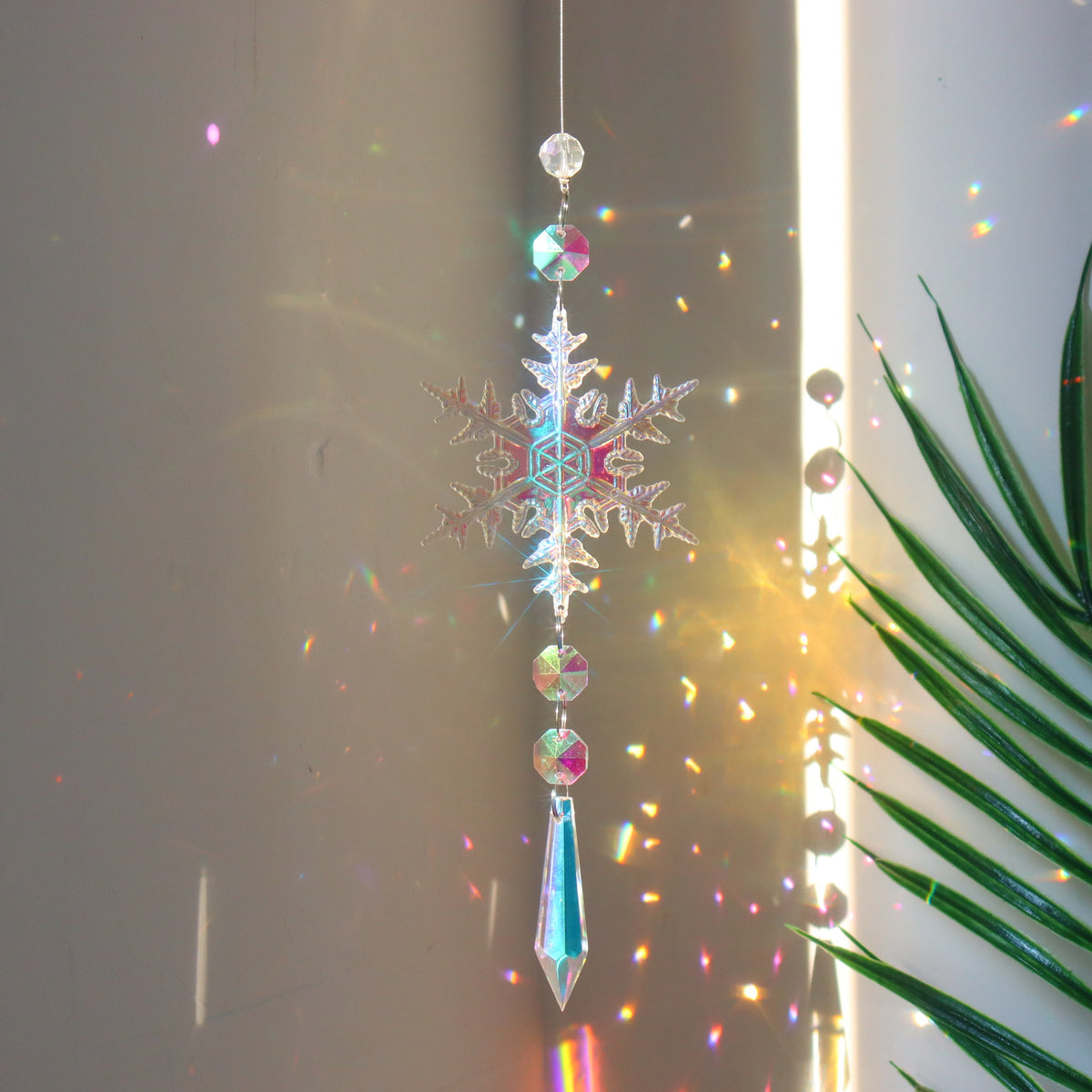 Beaded acrylic snowflake ornament ready to hang from a branch