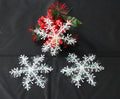 White plastic Christmas snowflake decorations, each 4.3 inches across