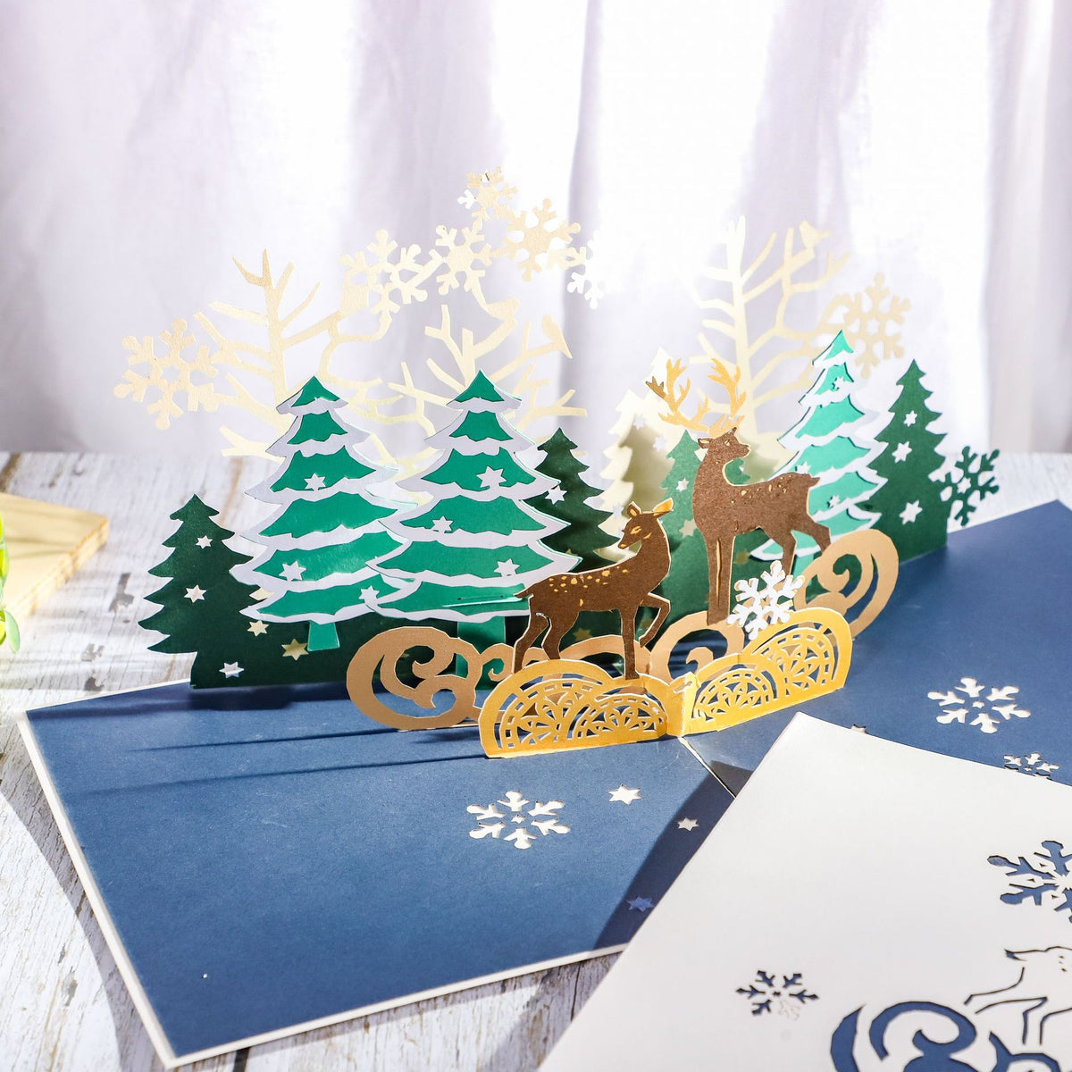Layered paper reindeer motif on the front of the Christmas card