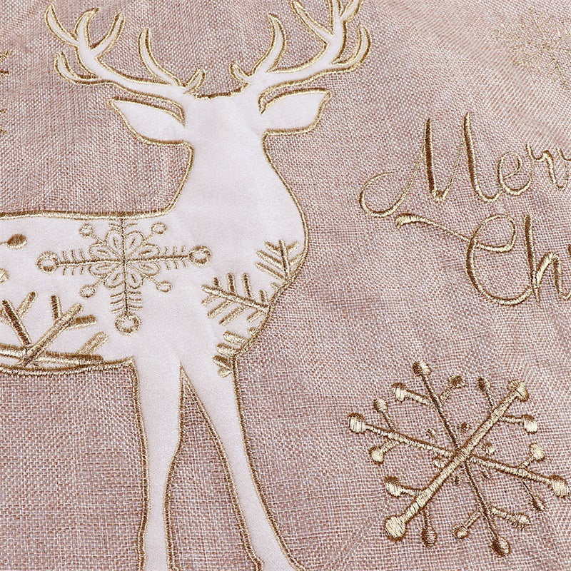 Gold thread running through the white linen of the Christmas tree skirt