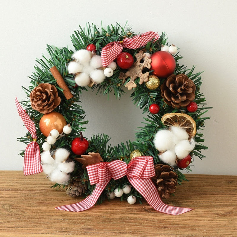 Christmas wreath of molded PVC branches finished with a tied fabric bow