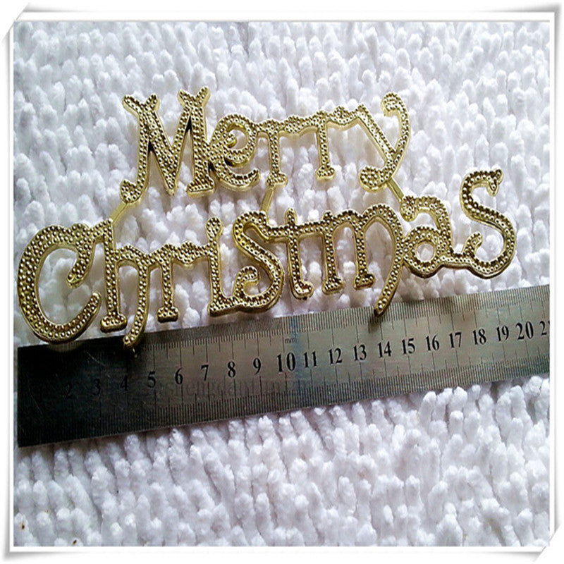 Gold colored plastic Christmas plaque with lettering as the pattern