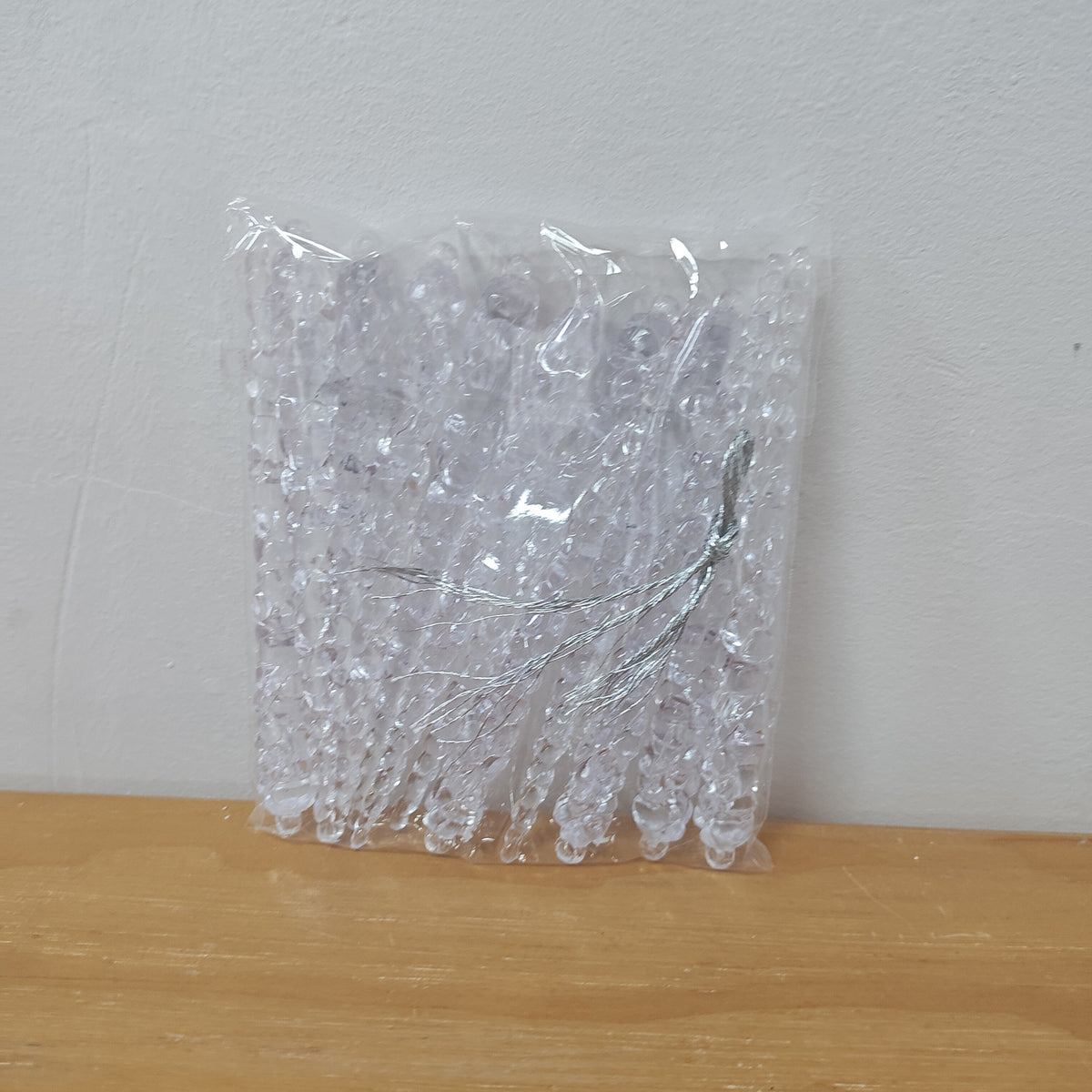 Colorless icicle ornament that suits green, white or colored trees